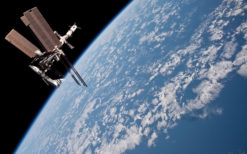 Space Station Orbiting Earth — Blue, Serene, Photograph, Clouds