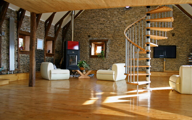 Spacious stone living room with spiral staircase