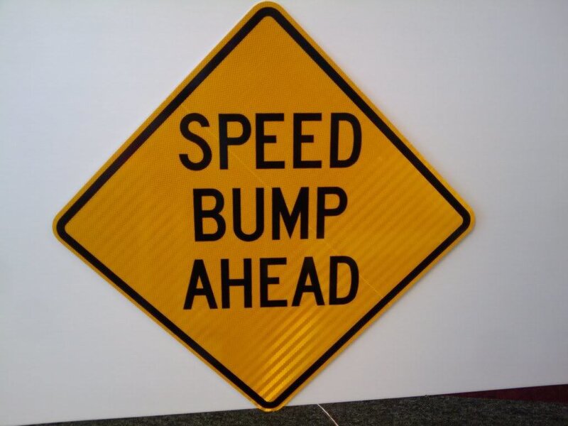 Speed bump ahead warning sign