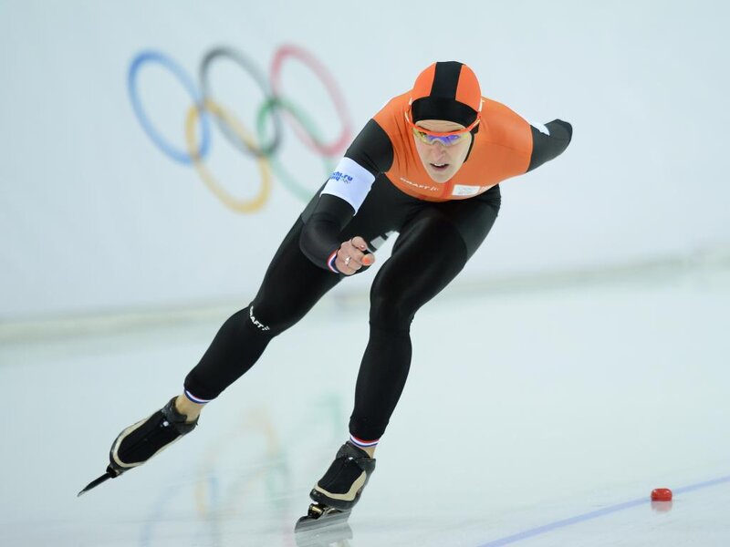 Speed Skater in Action — Orange, Focused, Photograph, Olympic Rings