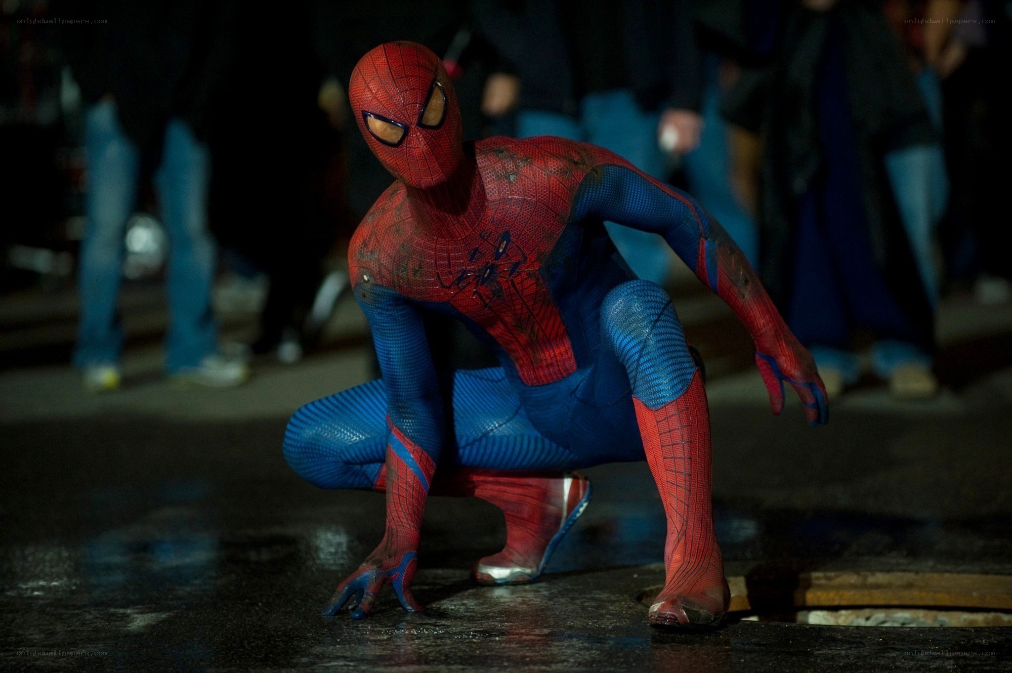 Spider-Man crouching on wet street