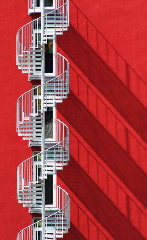 Spiral staircase on red wall