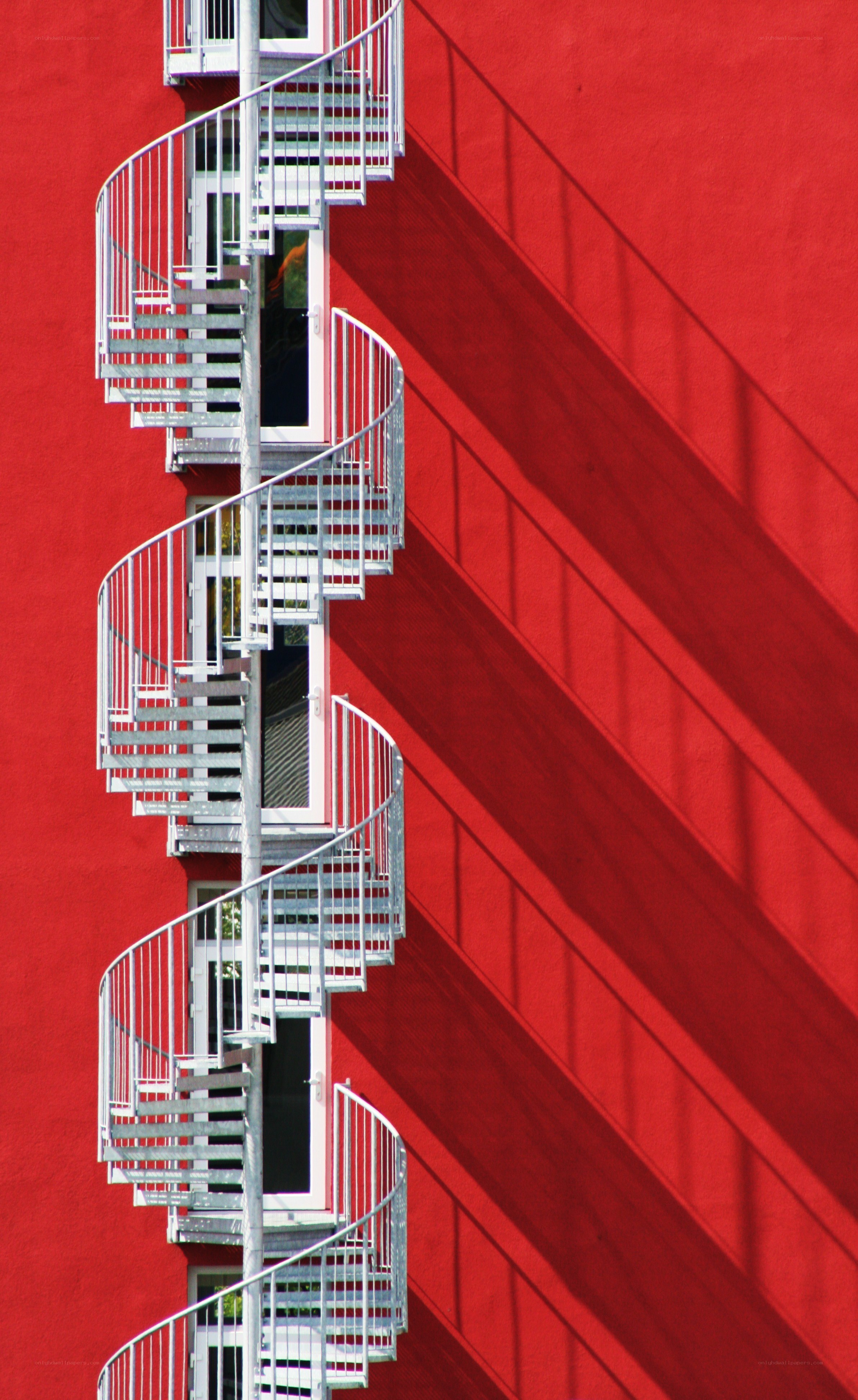Spiral staircase on red wall