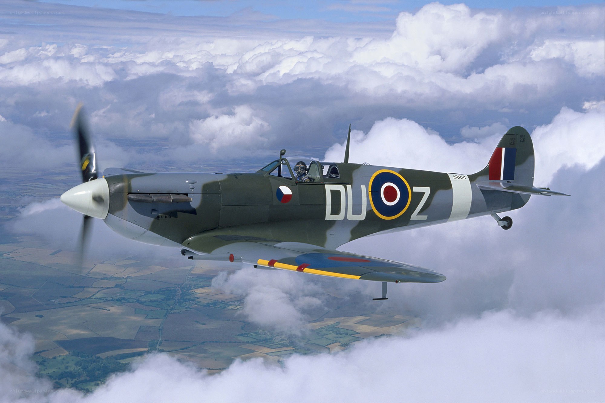 Spitfire in flight above clouds
