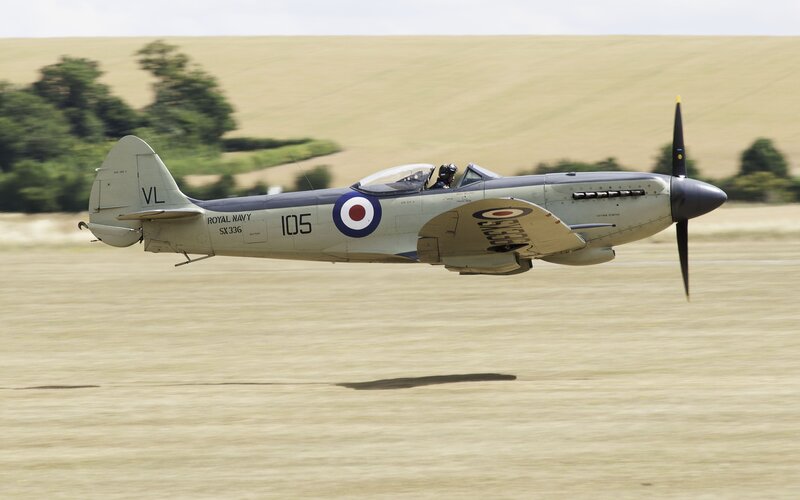 Spitfire in flight over field
