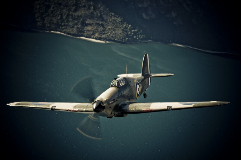Spitfire in flight over water