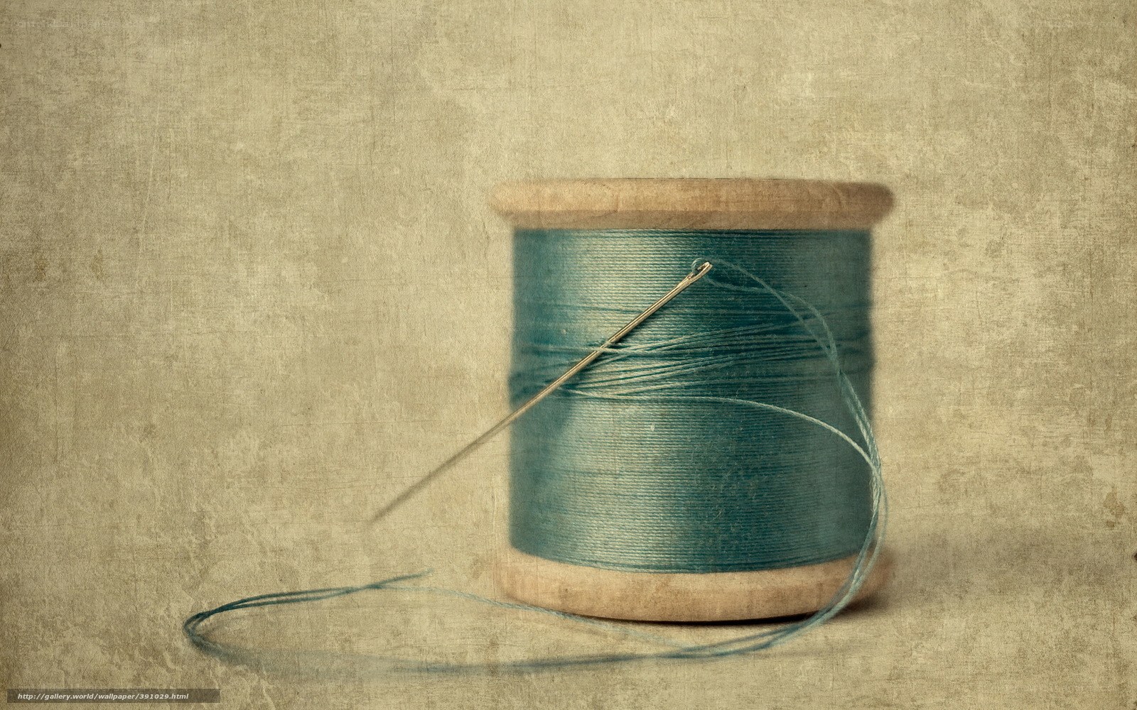 spool of blue thread with needle