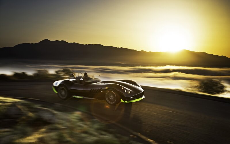 Sports car on mountain road at sunset