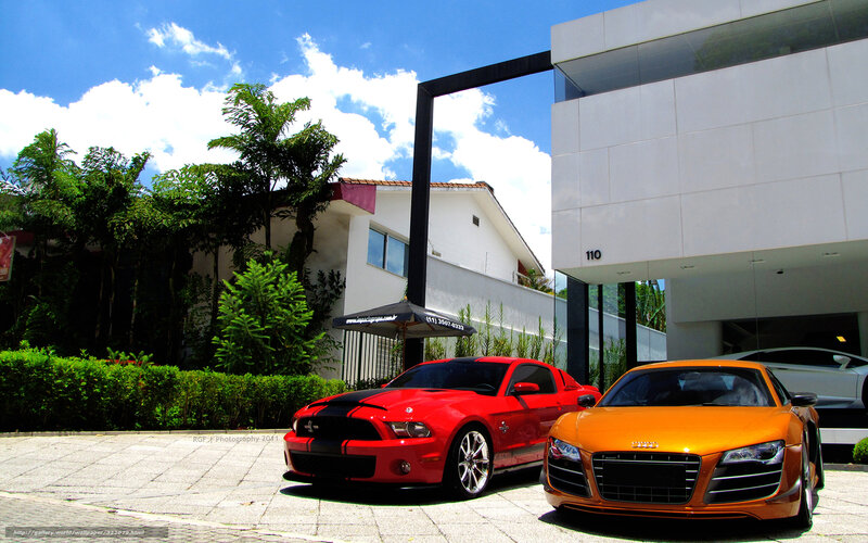 Sports cars in front of modern house