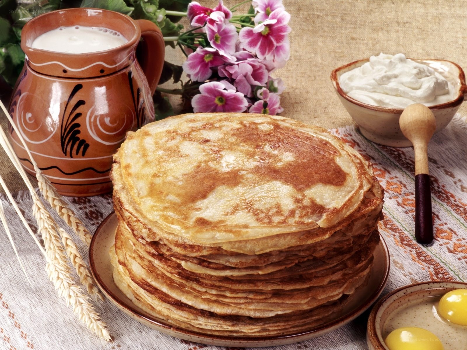 Stack of pancakes with milk and cream