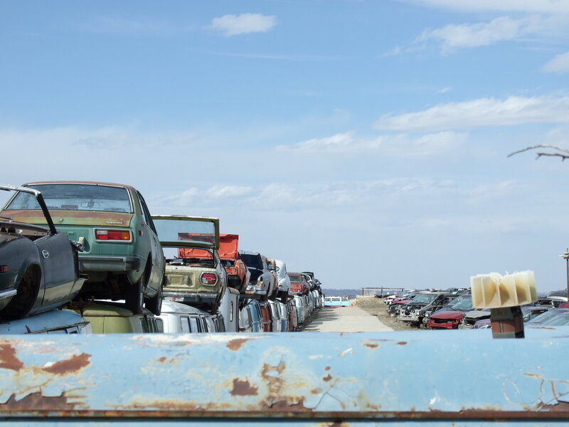 stacked cars in junkyard