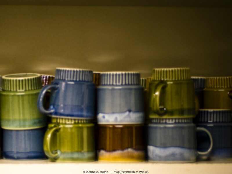 stacked ceramic mugs on shelf