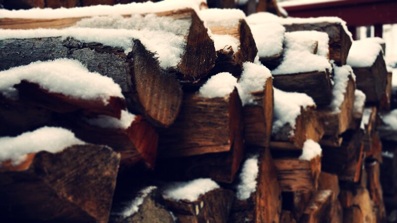 stacked firewood with snow