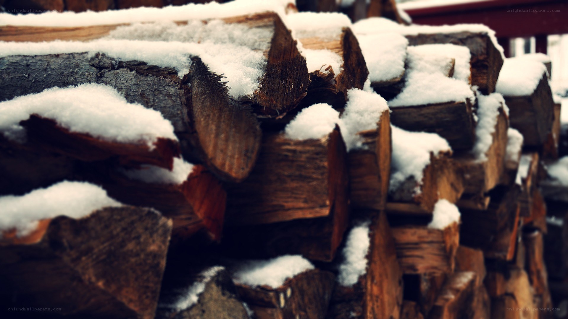 stacked firewood with snow