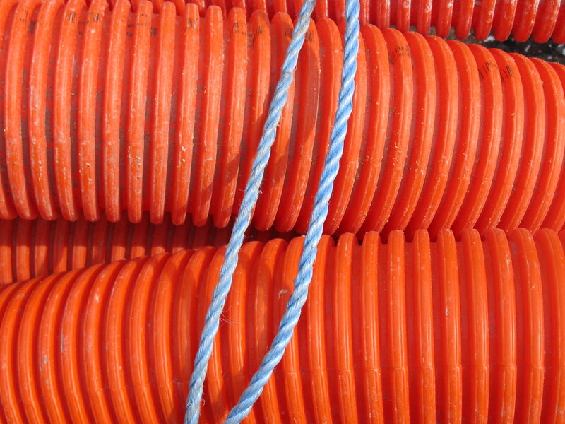 stacked orange pipes with rope