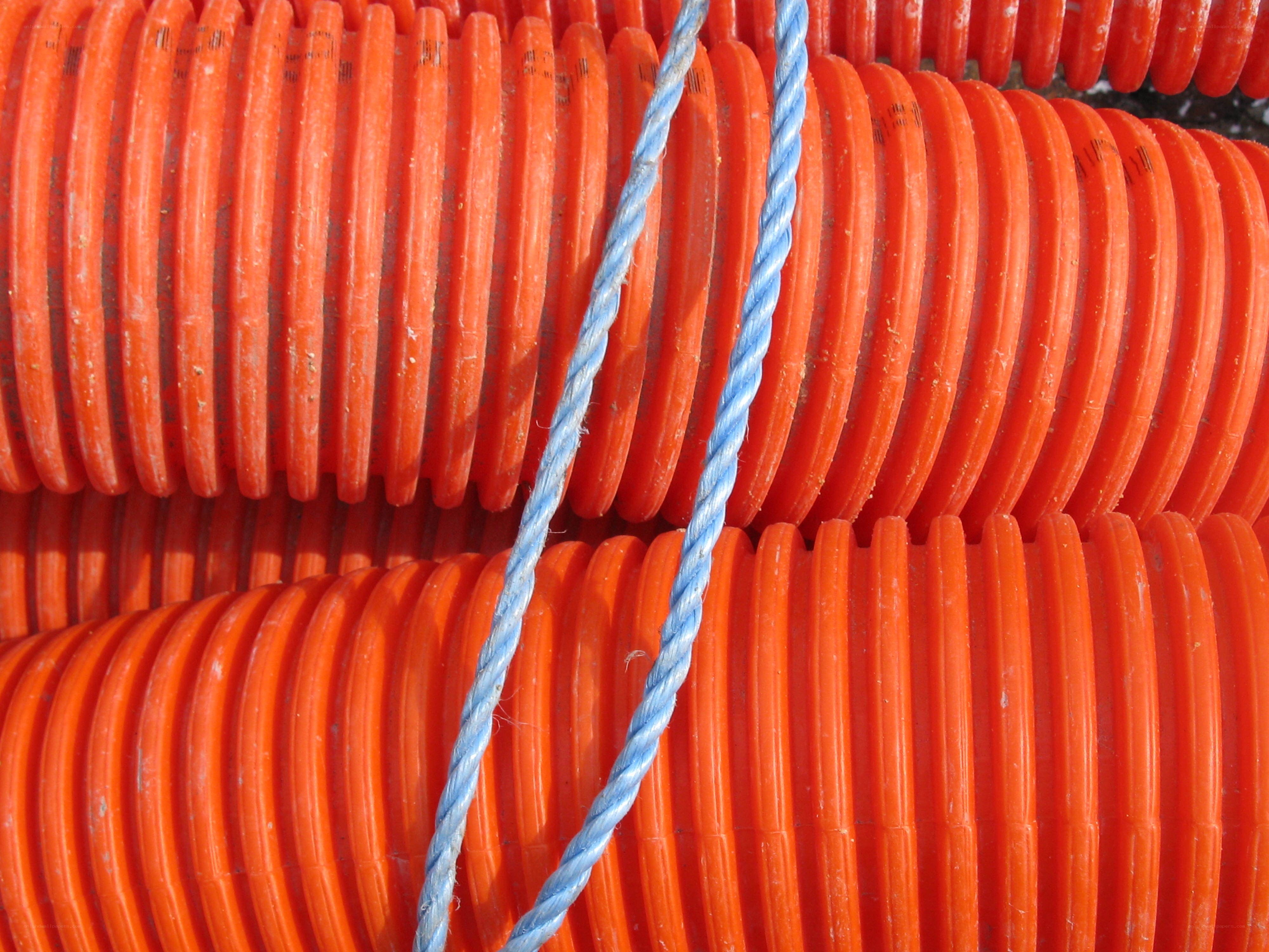 stacked orange pipes with rope