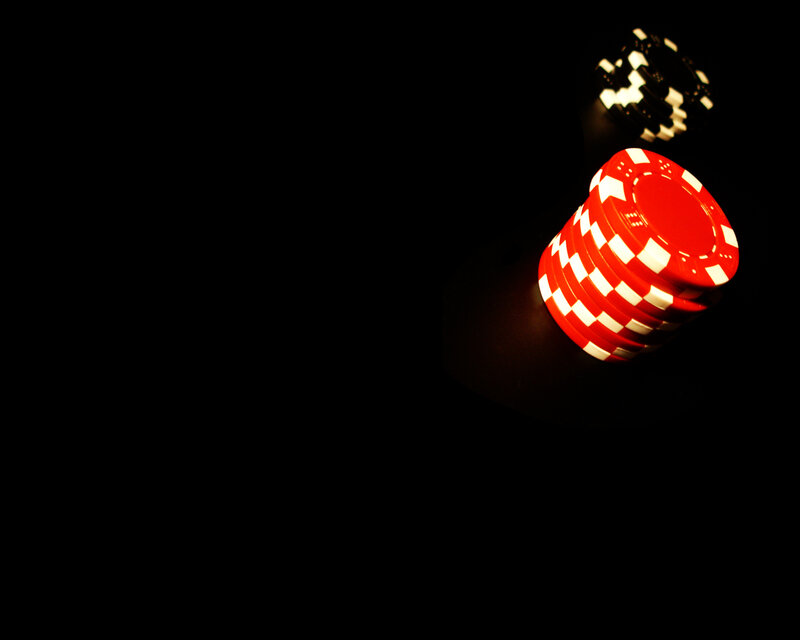 stacked poker chips on dark surface