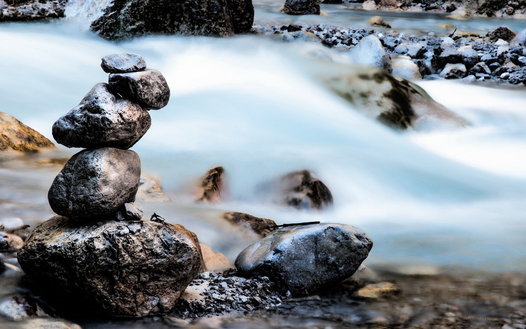 Stacked rocks by a flowing stream