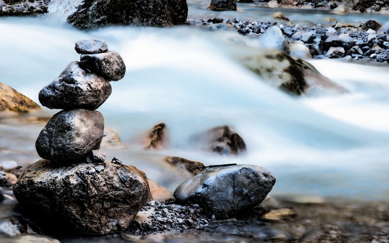 Stacked rocks by a flowing stream