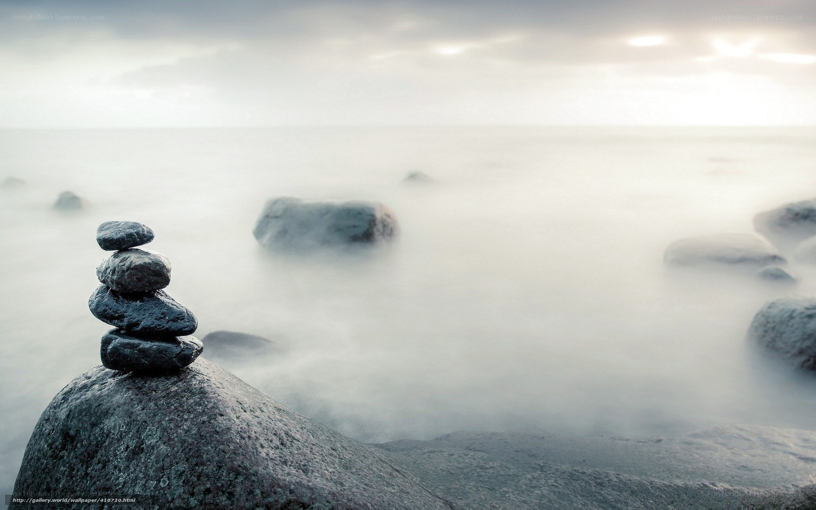 Stacked stones on a misty shore