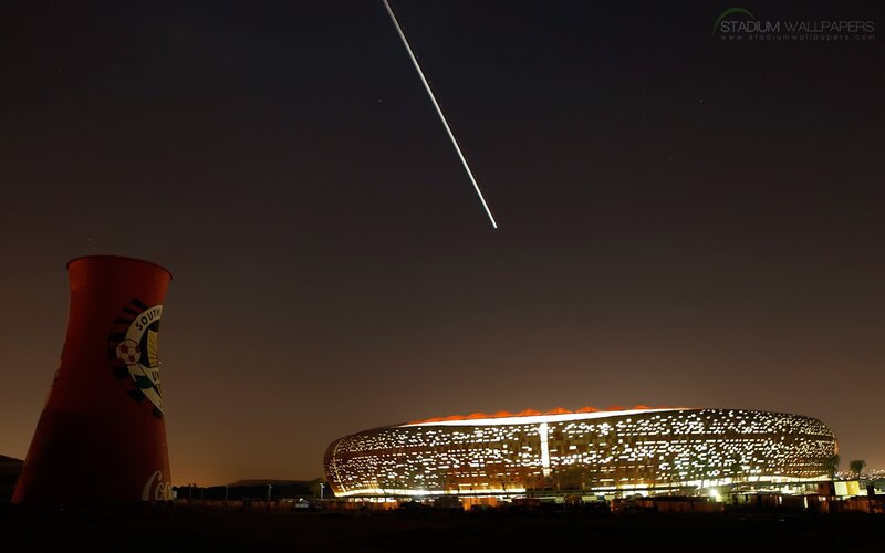 Stadium at night with contrail