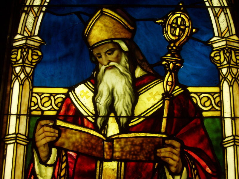 Stained glass of a bishop reading