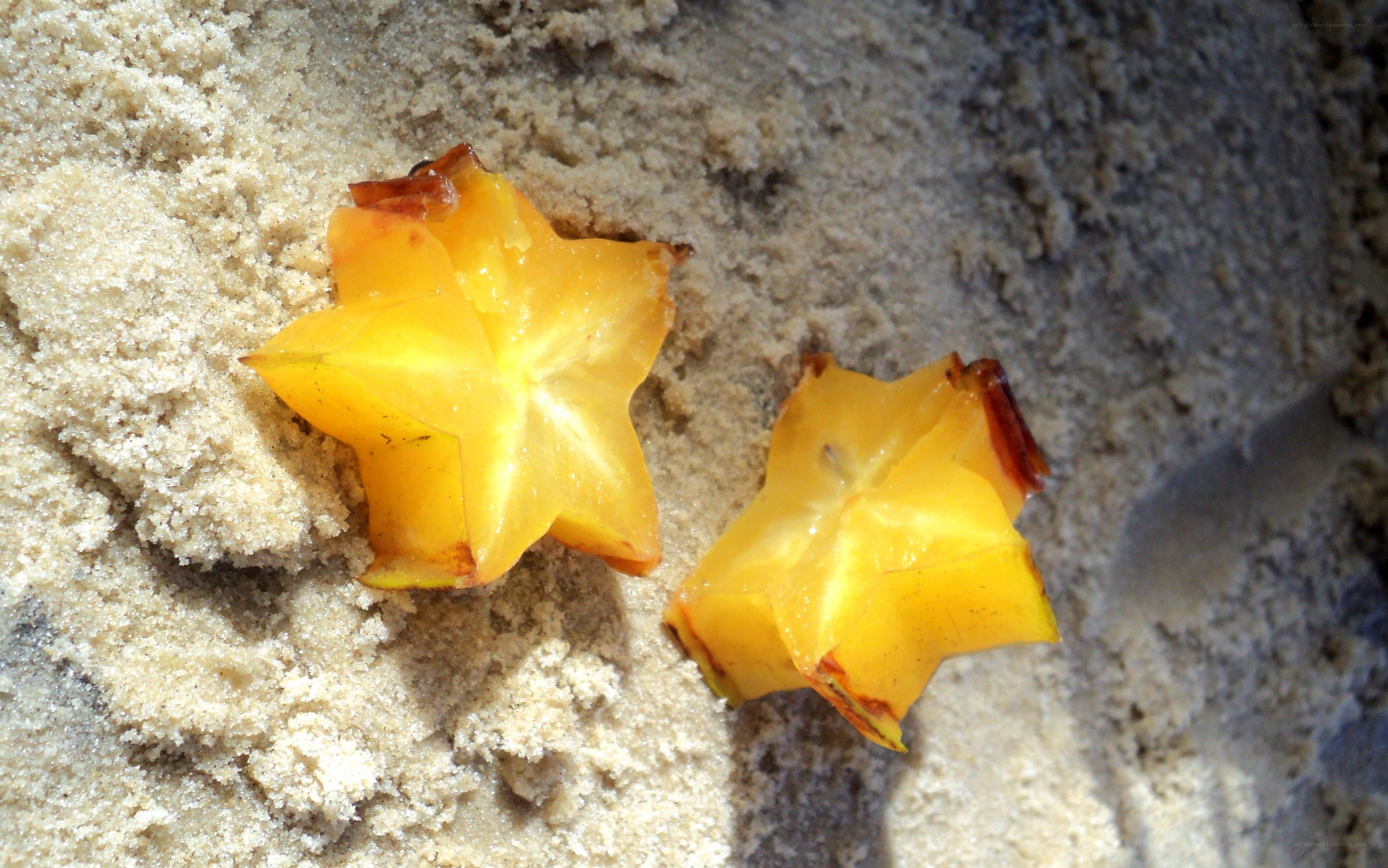 Star fruit slices on sand