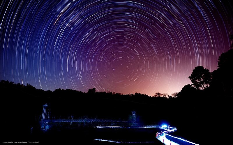 Star trails over a bridge