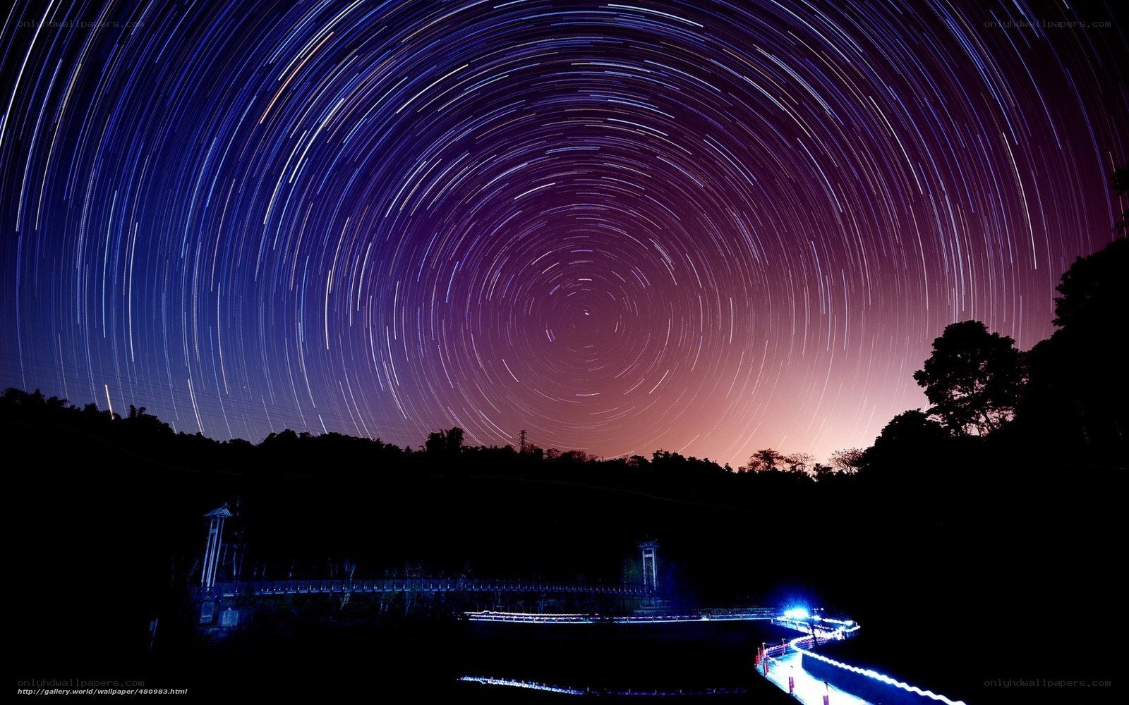 Star trails over a bridge