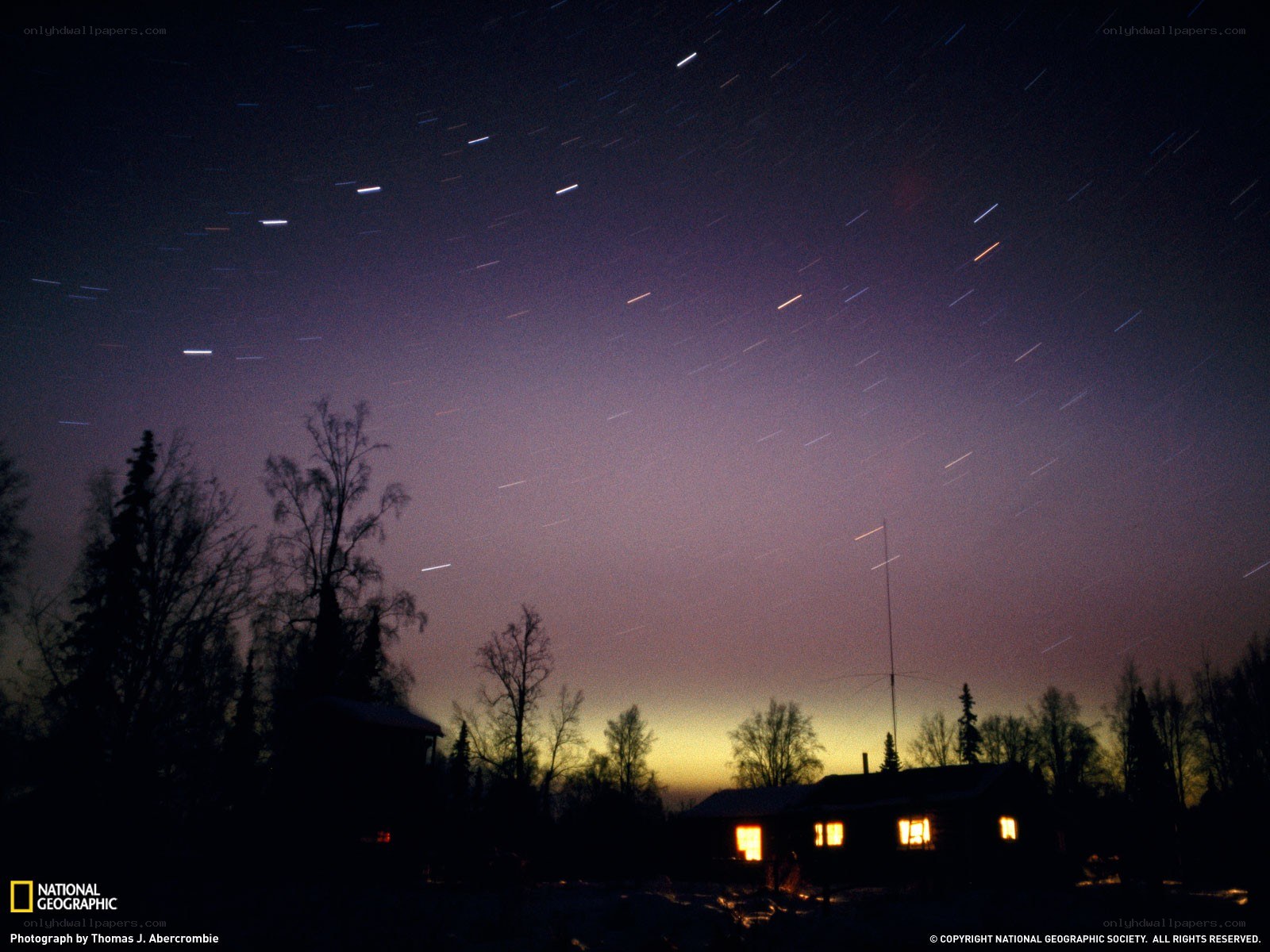Star trails over a cabin