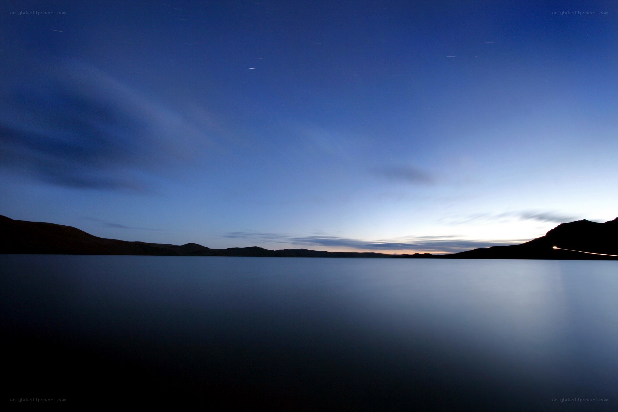 Star trails over a calm lake