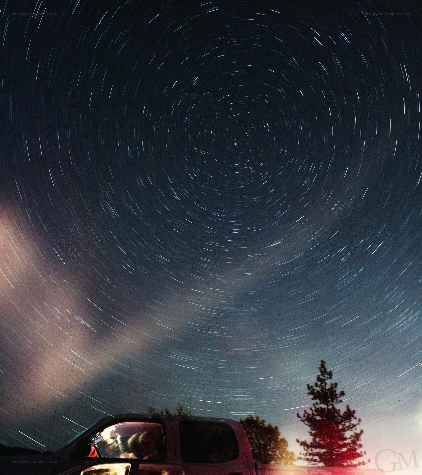 Star trails over a car