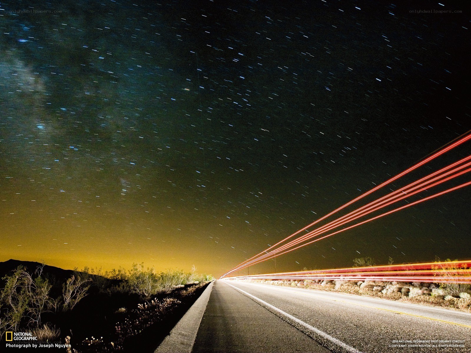 Star trails over a desert road