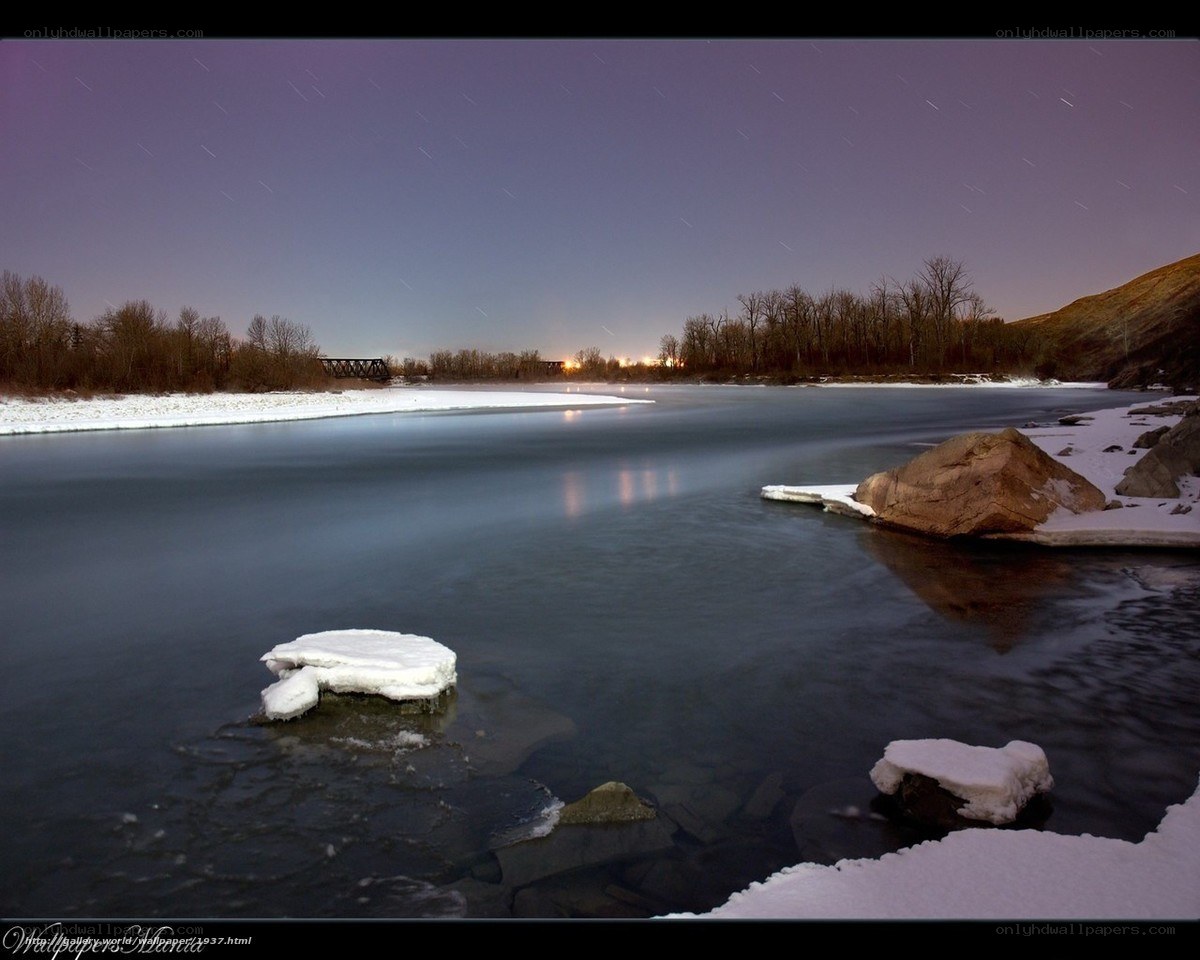 Star trails over a frozen river