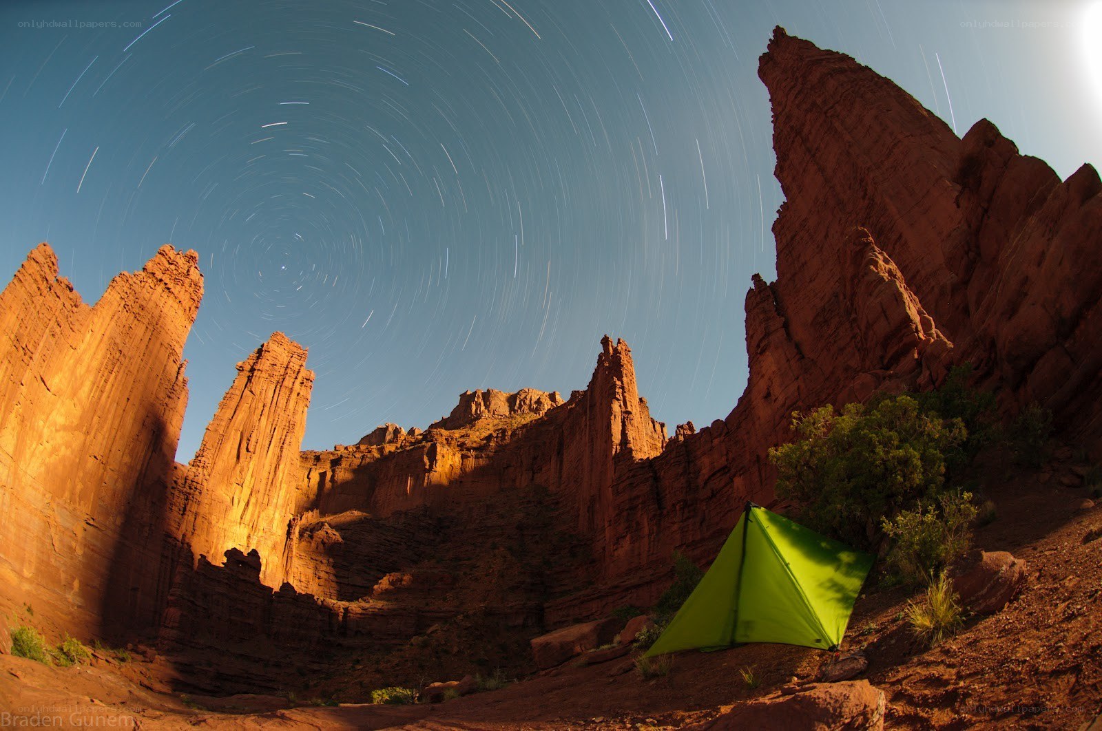 Star trails over a green tent
