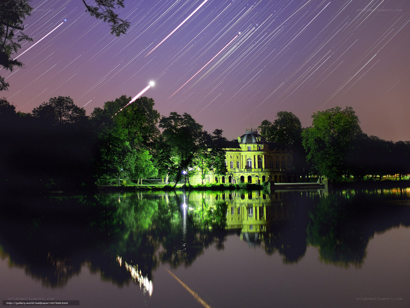 Star trails over a lake and mansion