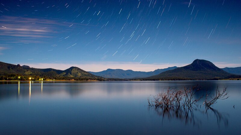 Star trails over a lake at night