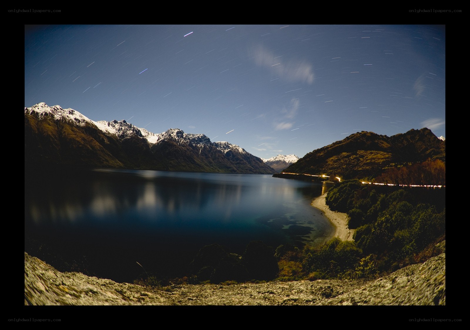 Star trails over a mountain lake