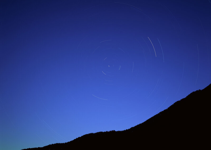 Star trails over a mountain silhouette