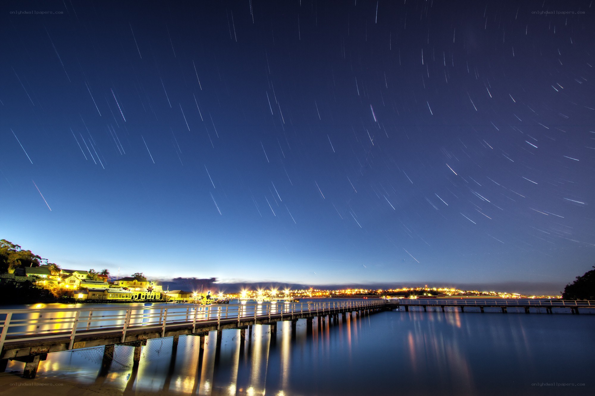 Star trails over a pier at night