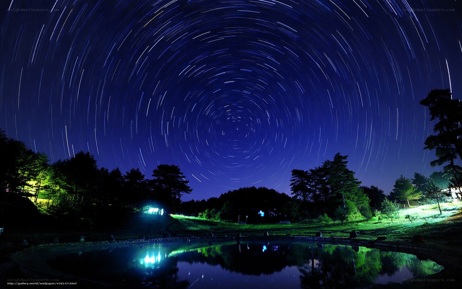 Star trails over a pond at night