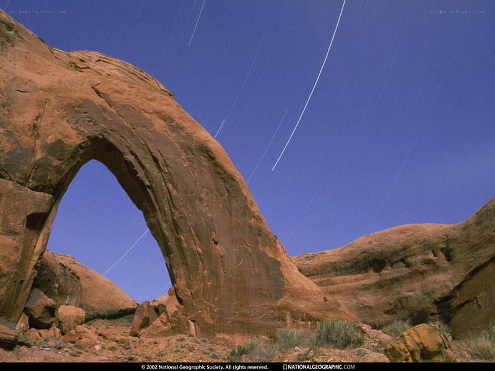 Star trails over a rock arch