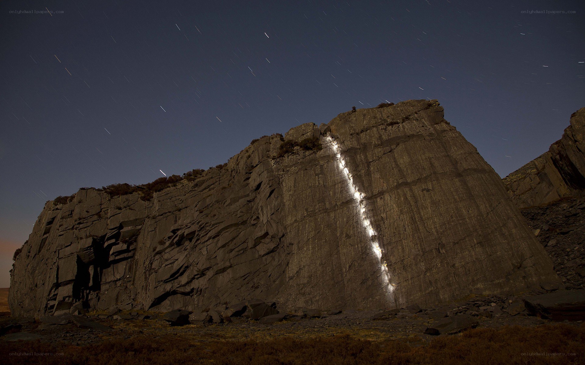 Star trails over a rock face