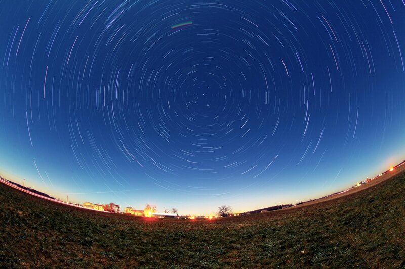 Star trails over a rural landscape