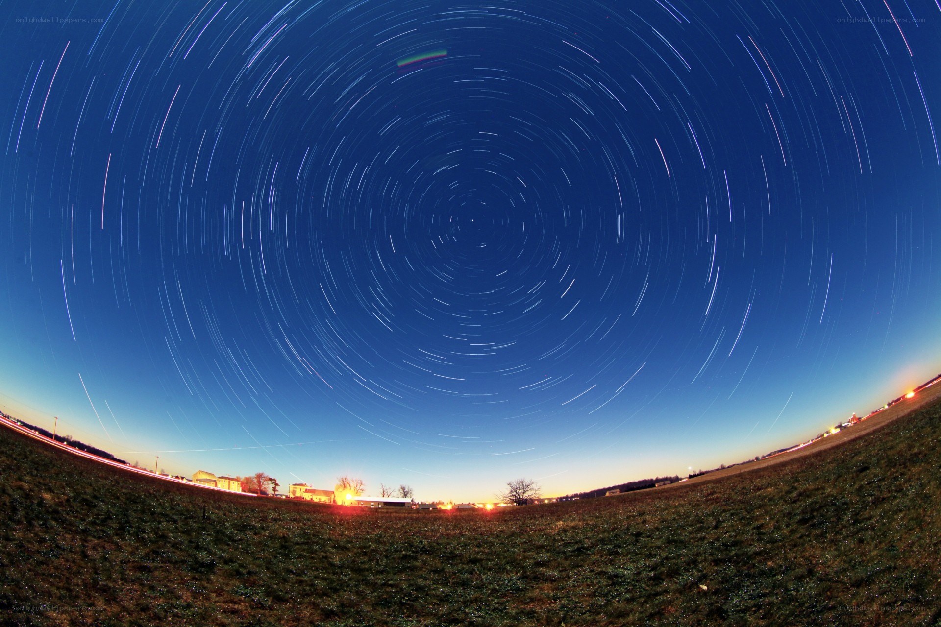 Star trails over a rural landscape