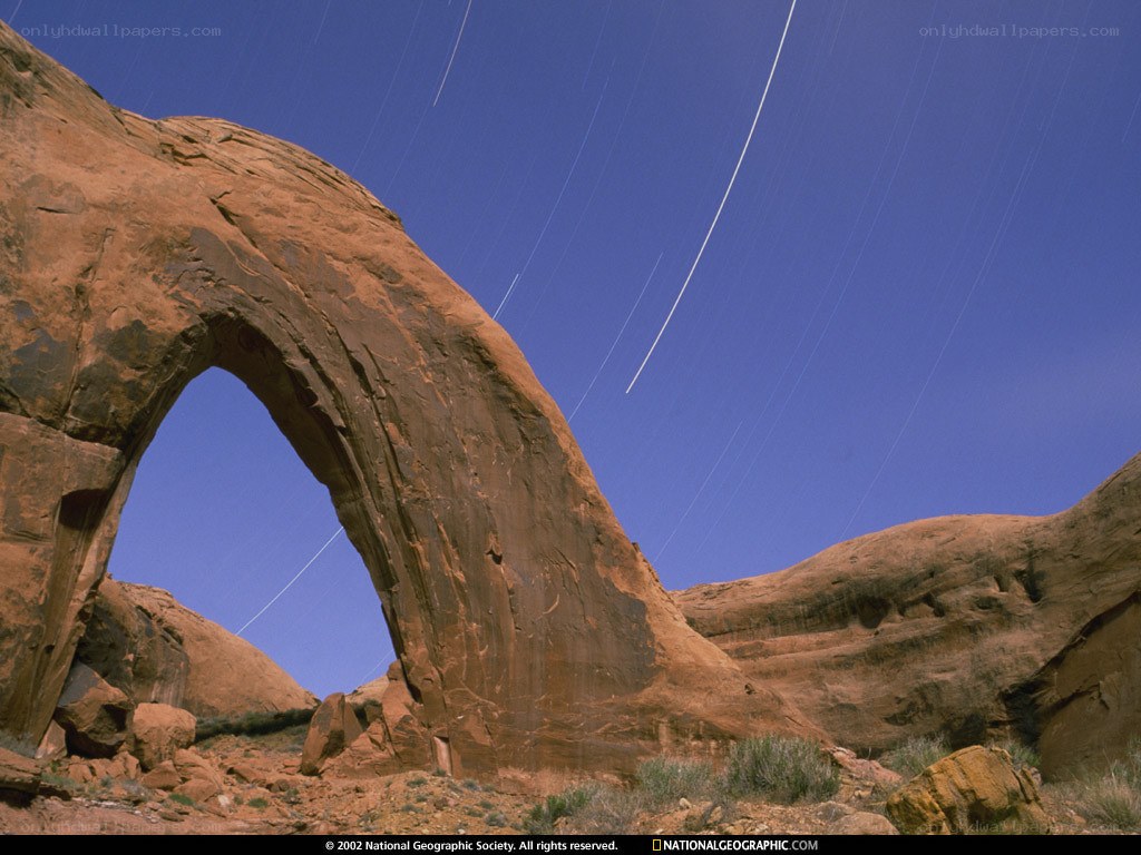 Star trails over a sandstone arch