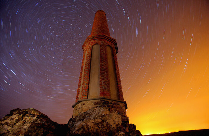 Star trails over brick tower