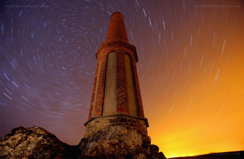Star trails over brick tower
