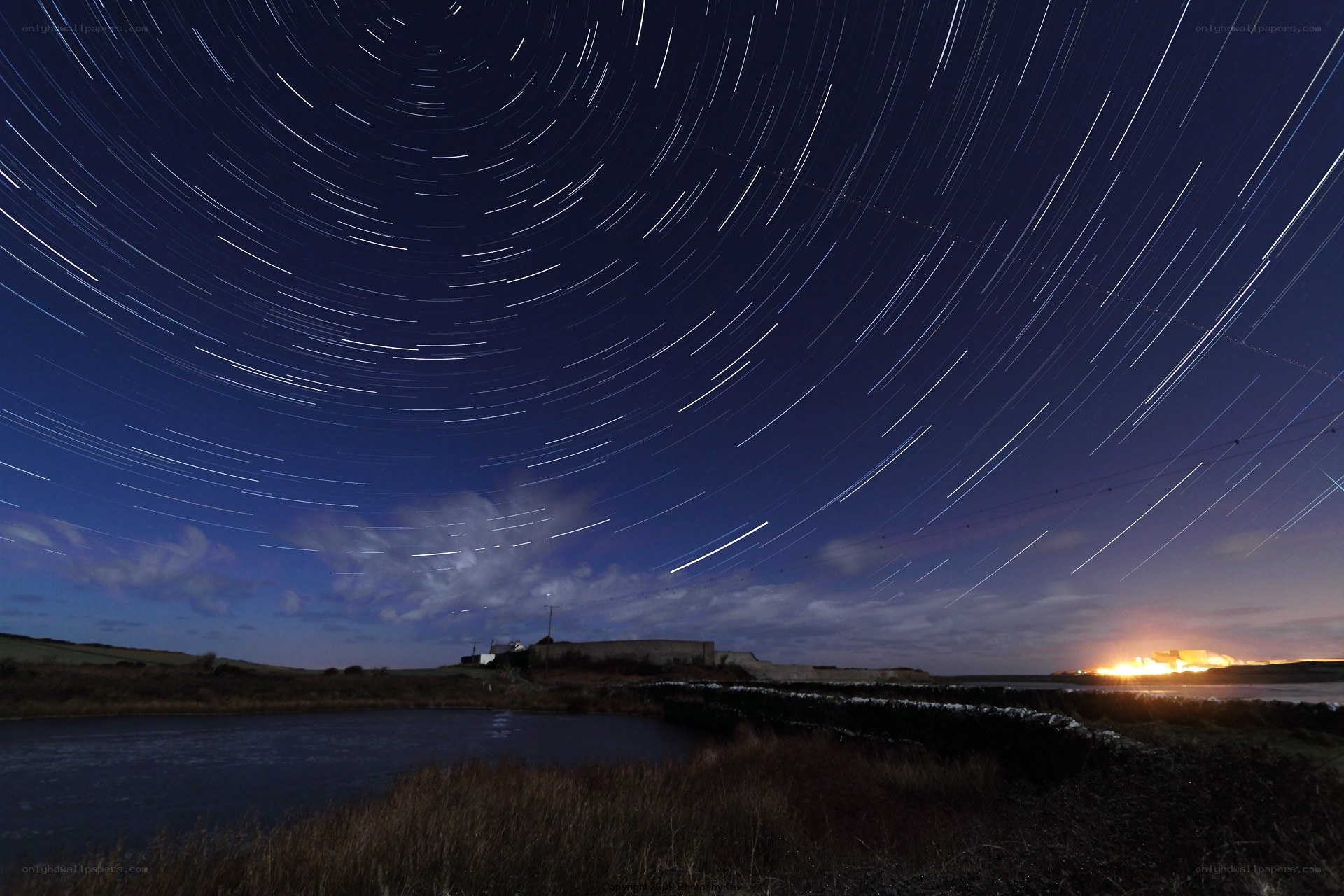 Star trails over coastal landscape