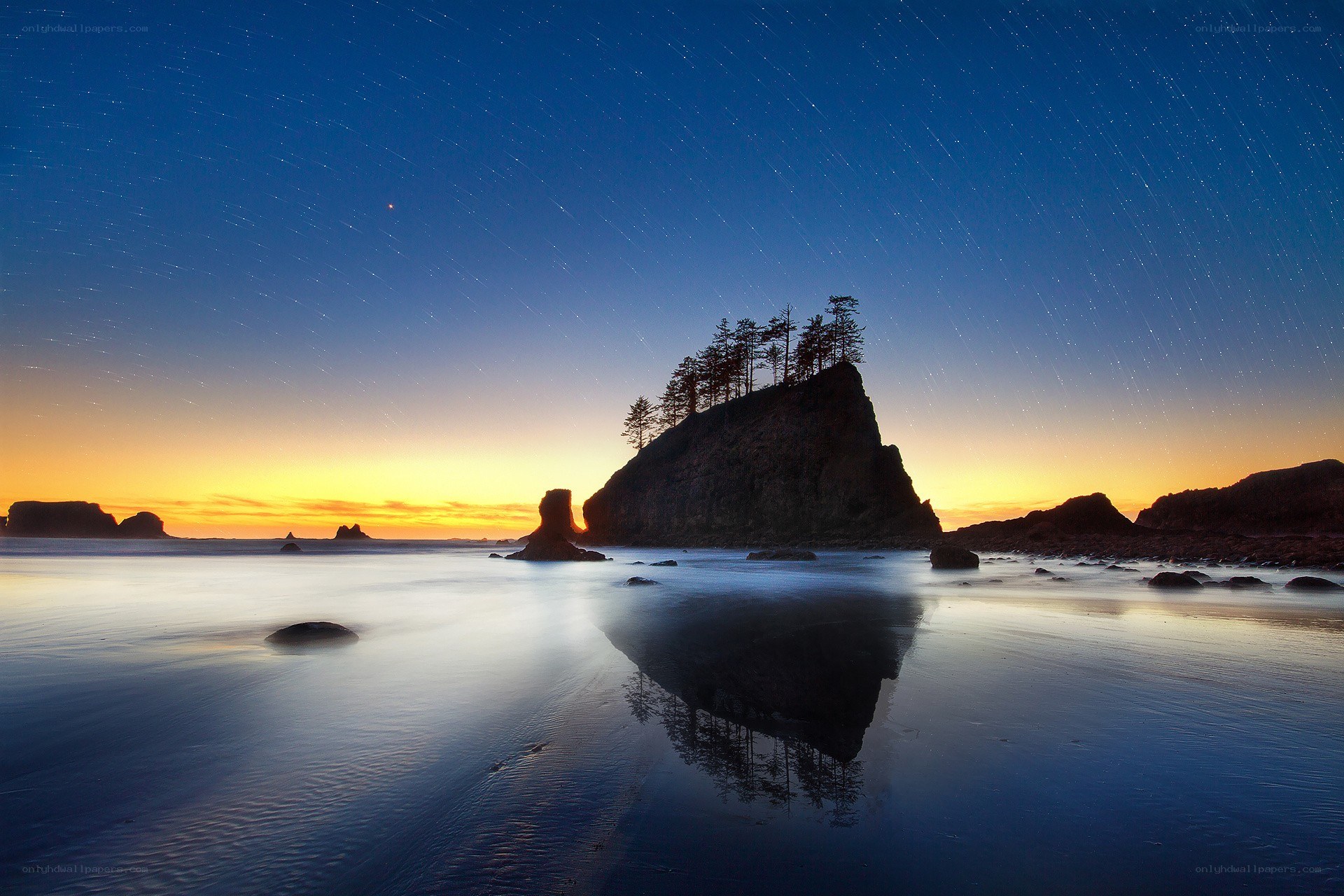 Star trails over coastal rocks